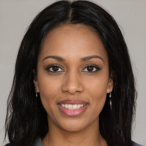 Joyful black young-adult female with long  black hair and brown eyes