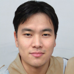 Joyful asian young-adult male with short  brown hair and brown eyes