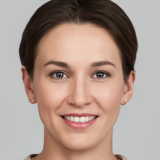 Joyful white young-adult female with short  brown hair and grey eyes