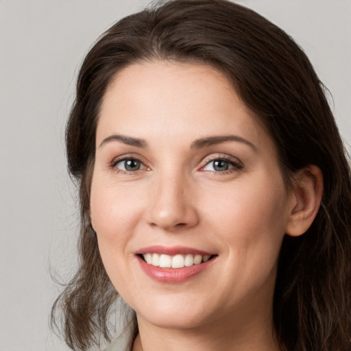 Joyful white young-adult female with long  brown hair and grey eyes