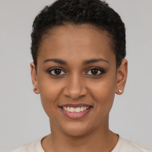 Joyful black young-adult female with short  black hair and brown eyes