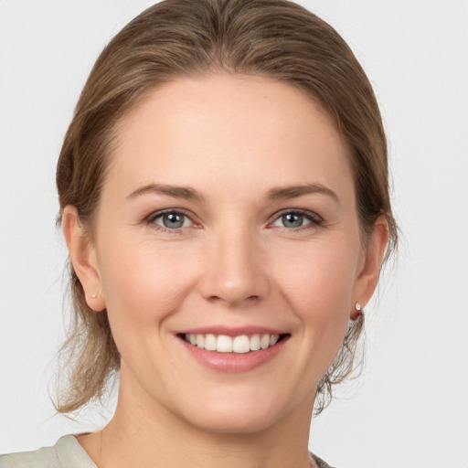 Joyful white young-adult female with medium  brown hair and grey eyes