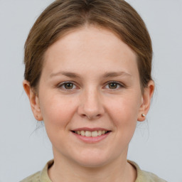 Joyful white young-adult female with short  brown hair and grey eyes