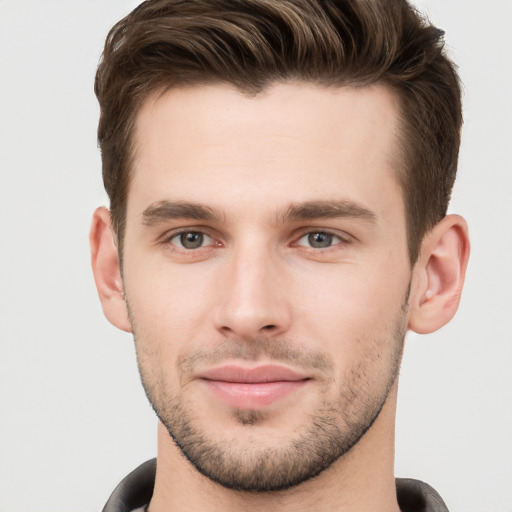 Joyful white young-adult male with short  brown hair and grey eyes