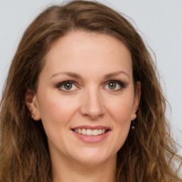 Joyful white young-adult female with long  brown hair and green eyes