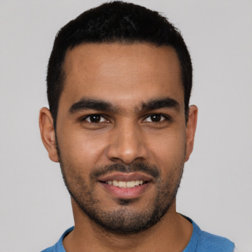 Joyful latino young-adult male with short  brown hair and brown eyes