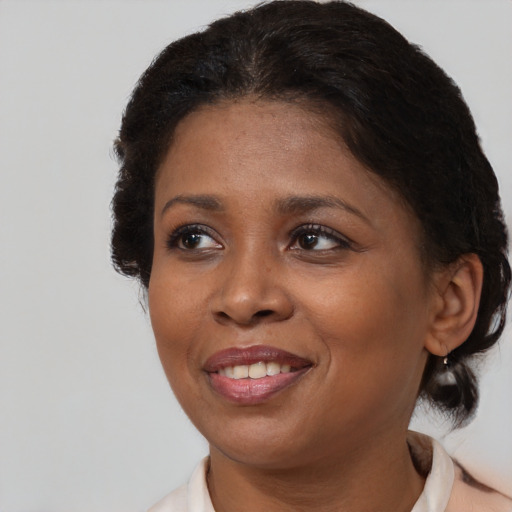 Joyful black adult female with medium  brown hair and brown eyes