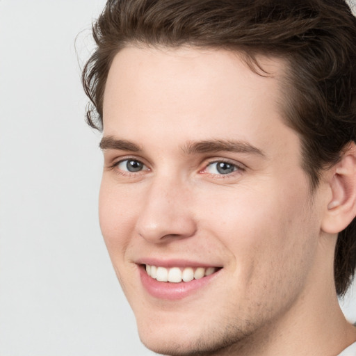 Joyful white young-adult male with medium  brown hair and brown eyes