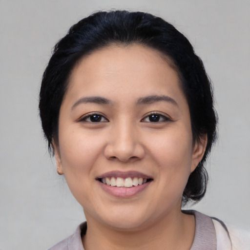 Joyful asian young-adult female with medium  black hair and brown eyes