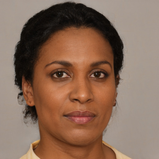 Joyful black adult female with short  brown hair and brown eyes
