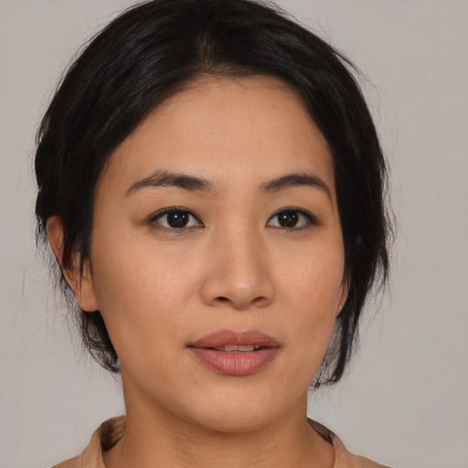 Joyful asian young-adult female with medium  brown hair and brown eyes