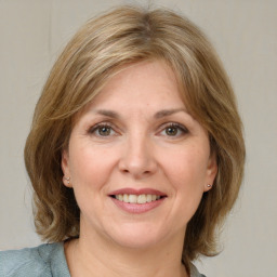 Joyful white adult female with medium  brown hair and grey eyes