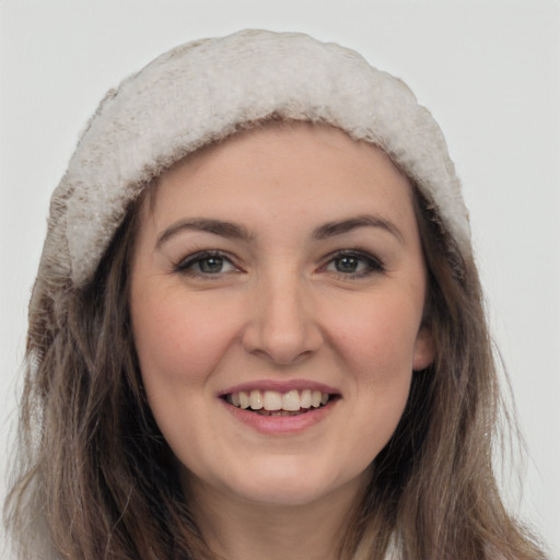 Joyful white young-adult female with long  brown hair and grey eyes