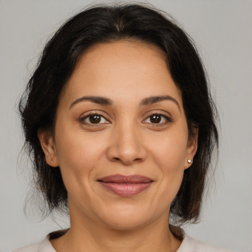 Joyful latino adult female with medium  brown hair and brown eyes