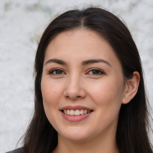 Joyful white young-adult female with long  brown hair and brown eyes