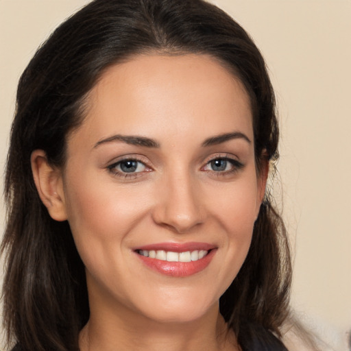 Joyful white young-adult female with long  brown hair and brown eyes