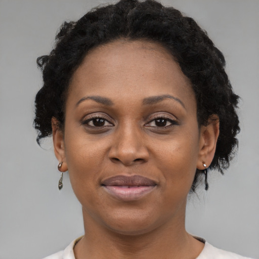 Joyful black young-adult female with short  brown hair and brown eyes
