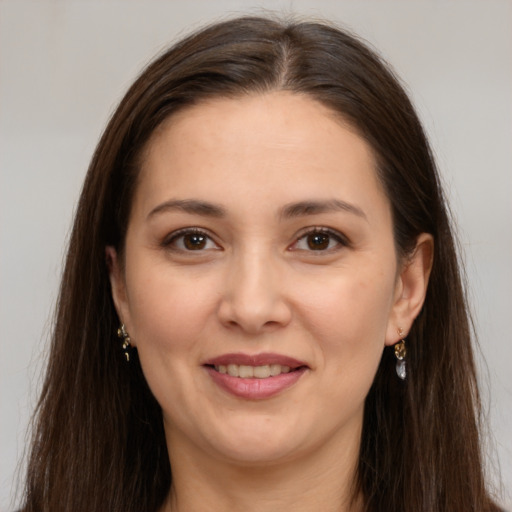 Joyful white young-adult female with long  brown hair and brown eyes