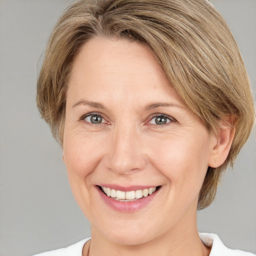 Joyful white adult female with medium  brown hair and grey eyes