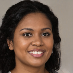 Joyful black young-adult female with long  brown hair and brown eyes