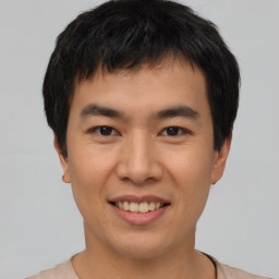 Joyful asian young-adult male with short  black hair and brown eyes