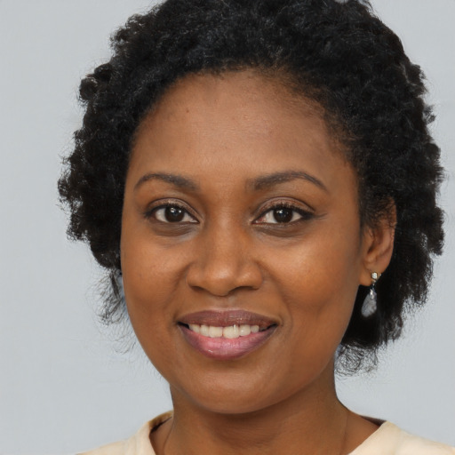 Joyful black adult female with long  brown hair and brown eyes