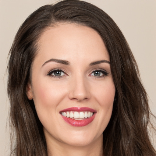 Joyful white young-adult female with long  brown hair and brown eyes