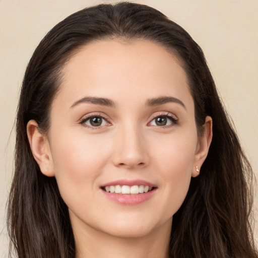 Joyful white young-adult female with long  brown hair and brown eyes