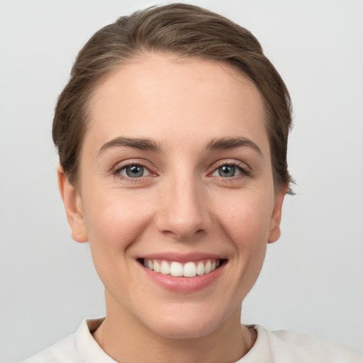 Joyful white young-adult female with short  brown hair and grey eyes