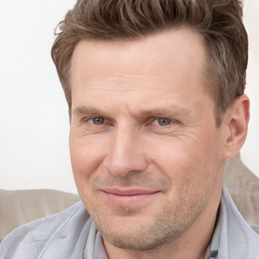 Joyful white adult male with short  brown hair and grey eyes