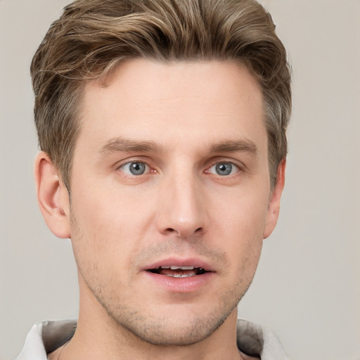 Joyful white young-adult male with short  brown hair and grey eyes