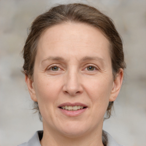 Joyful white adult female with medium  brown hair and grey eyes