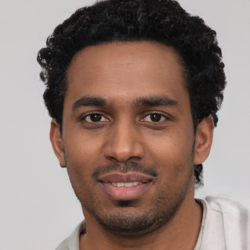 Joyful black young-adult male with short  black hair and brown eyes