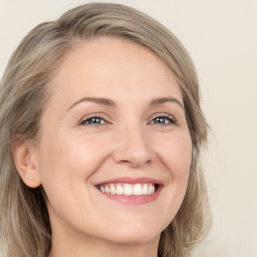 Joyful white adult female with long  brown hair and green eyes