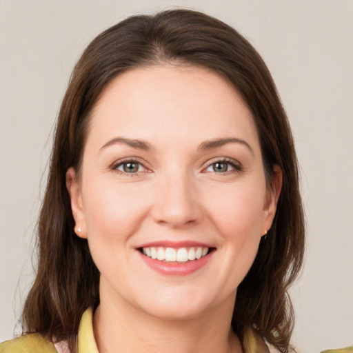 Joyful white young-adult female with medium  brown hair and grey eyes