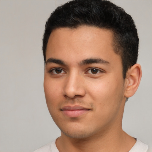 Joyful latino young-adult male with short  black hair and brown eyes