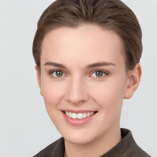 Joyful white young-adult female with short  brown hair and grey eyes