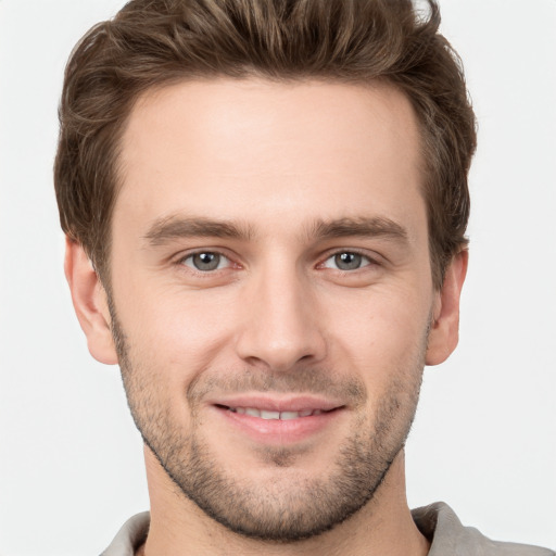 Joyful white young-adult male with short  brown hair and grey eyes