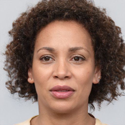 Joyful black adult female with medium  brown hair and brown eyes