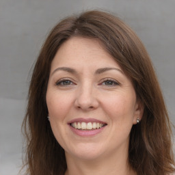 Joyful white adult female with long  brown hair and brown eyes