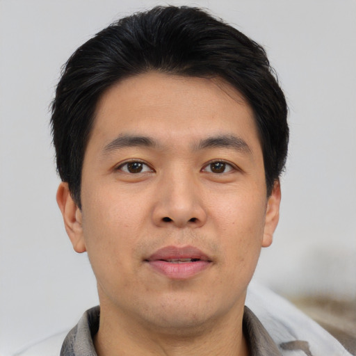 Joyful asian young-adult male with short  black hair and brown eyes