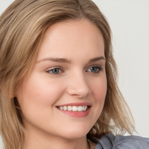 Joyful white young-adult female with long  brown hair and blue eyes