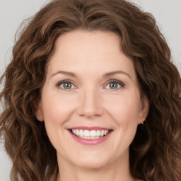 Joyful white young-adult female with long  brown hair and green eyes