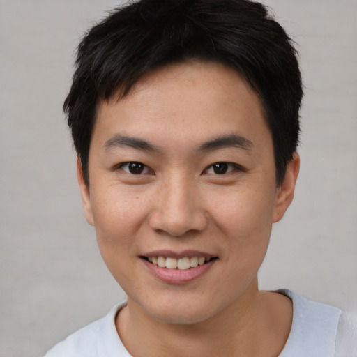 Joyful asian young-adult male with short  black hair and brown eyes