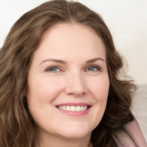 Joyful white young-adult female with long  brown hair and blue eyes