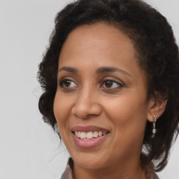 Joyful black adult female with long  brown hair and brown eyes