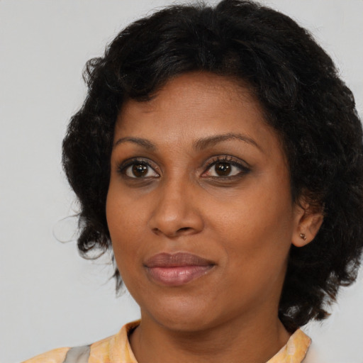 Joyful black adult female with medium  brown hair and brown eyes