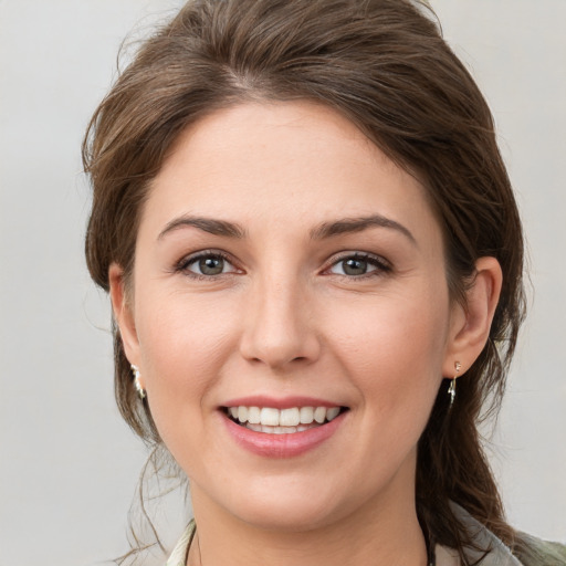 Joyful white young-adult female with medium  brown hair and grey eyes