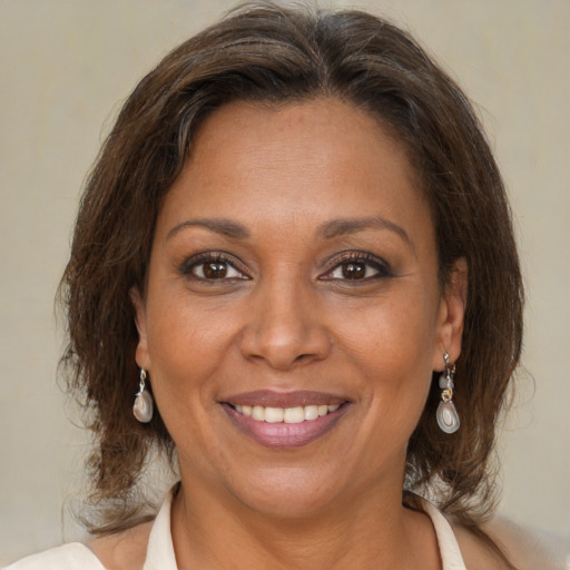 Joyful black adult female with medium  brown hair and brown eyes