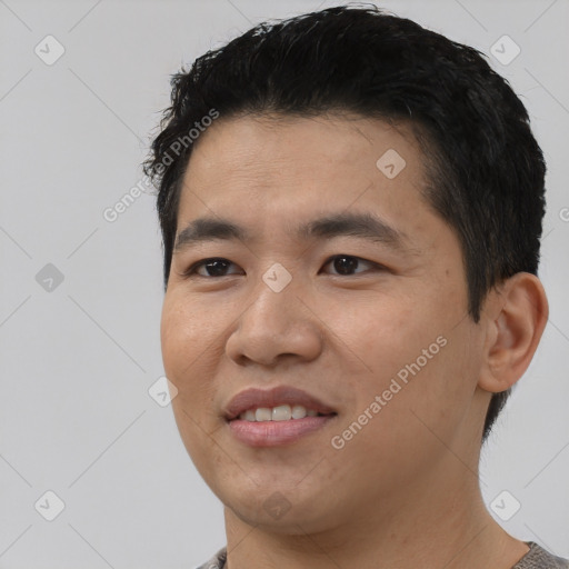 Joyful asian young-adult male with short  black hair and brown eyes